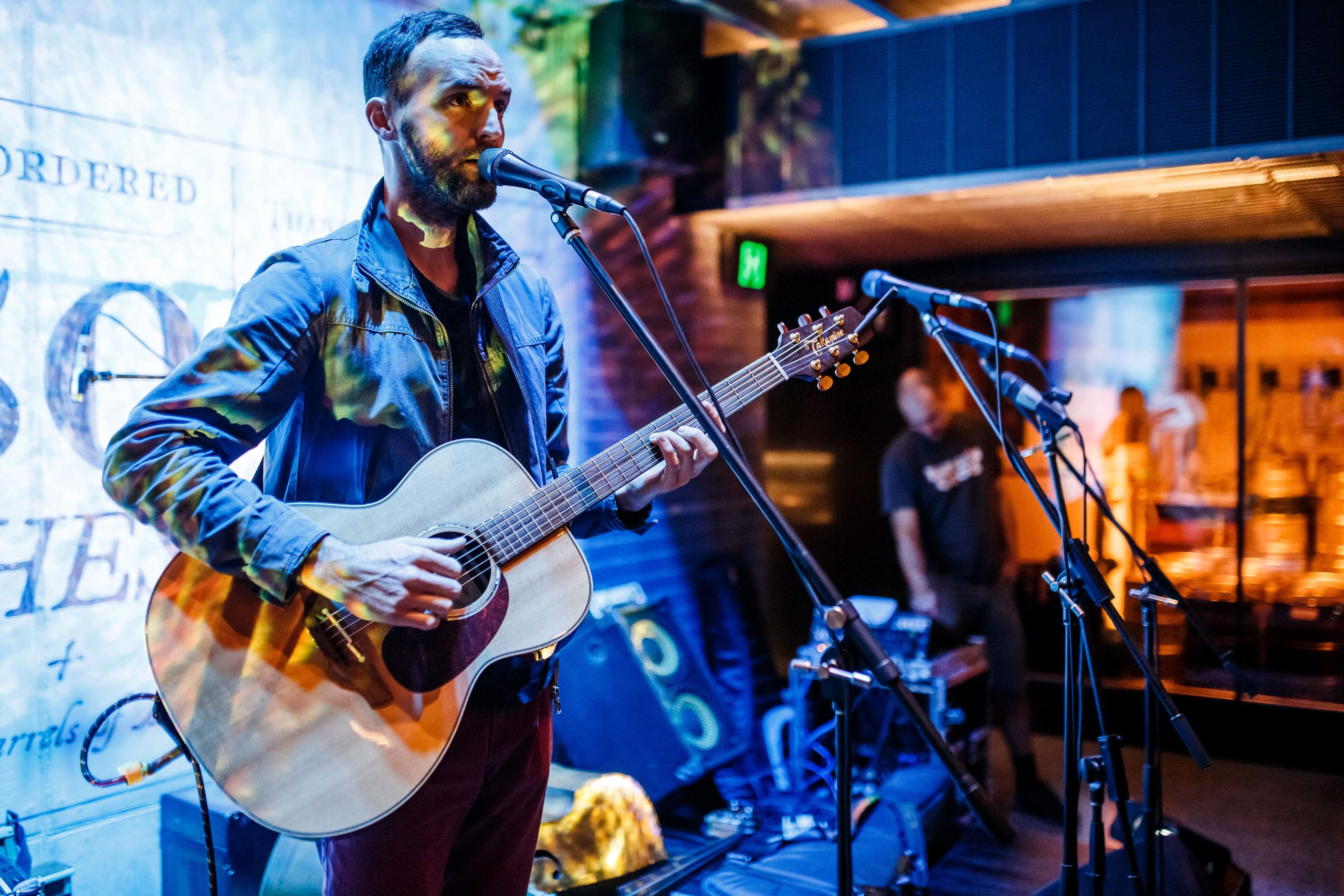 A musician singing and playing an acoustic guitar